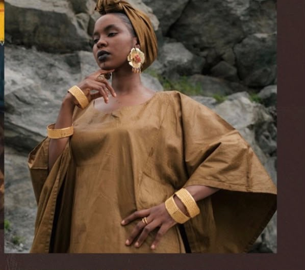 Femme en boubou doré et bijoux raffia